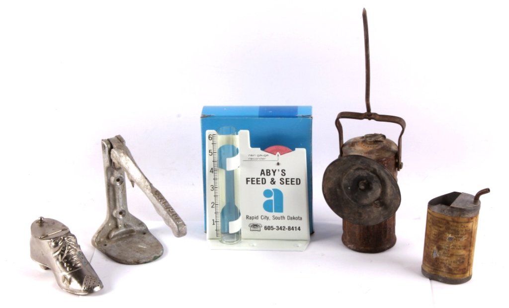 1900's Collectibles This lot includes several 1900: This lot includes several 1900's collectibles. There is a Champion can opener, a Coleman measuring can, a miner's carbide lantern, a shoe spittoon, and a rain gauge advertisement. The carbide lamp app