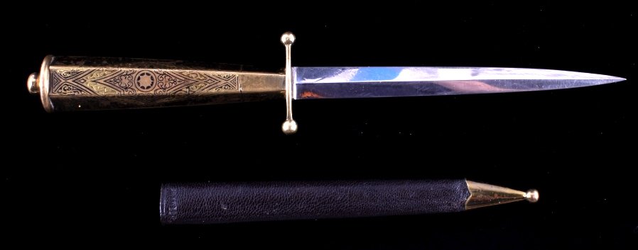 German Brass Dagger Letter Opener This lot feature: This lot features brass handled dagger letter opener with scabbard. The opener has a fancy engraved handle made of brass. The scabbard is marked "GERMANY" and features a brass tip to match the opener.