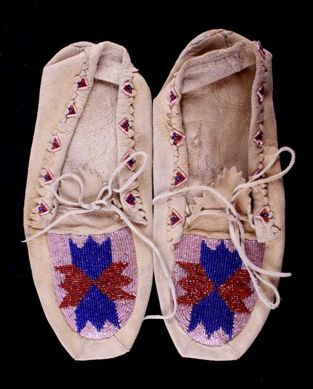 Plateau Indian Beaded Moccasins The lot features a: The lot features an original early set of Indian tanned hide moccasins with trade glass seed beadwork. The moccasins are from the Plateau Native American Indians. The top edge has a cut edge with fanc