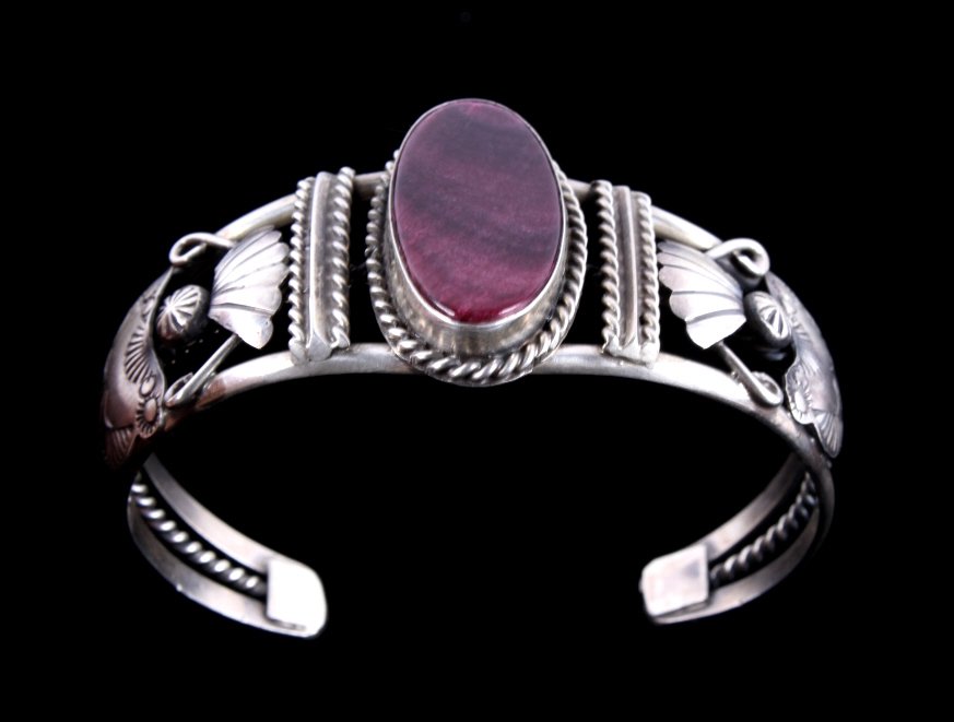 Navajo Sugilite & Sterling Tooled Cuff Bracelet Th: The lot features a wonderfully tooled sterling silver bracelet from Navajo Native American artist, Betta Lee. The piece is from the 1970's. Hallmarked "B Lee" & "Sterling". Measures 2"x2.5"