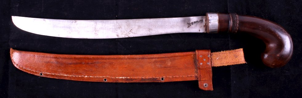 Wooden Handled Machete This is a wooden handled ma: This is a wooden handled machete with scabbard. The machete has a curved wooden handle with a hand carved grip. The blade is marked "S-RRN". The scabbard is made from leather. The machete and scabbard