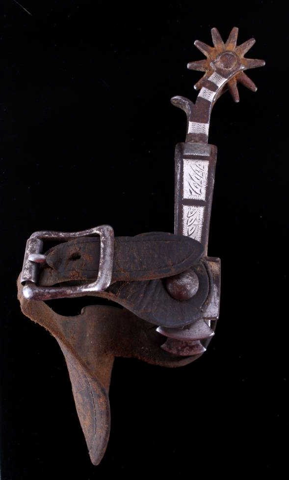 August Buermann Silver Mounted Single Spur This is: This is an early original August Buermann western cowboy spur. The spur shows a single mounted design with six different hand etched sections. The spur also has a tooled strap and is believed to be fr