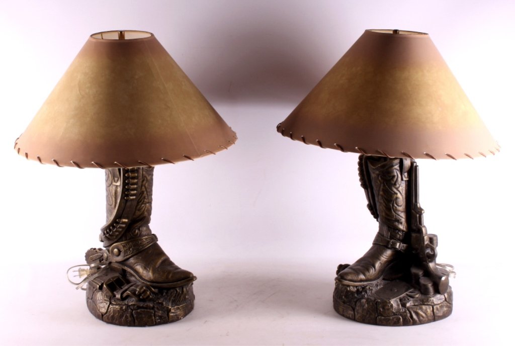 Cowboy Boot and Gun Belt Table Lamps This is a pai: This is a pair of cowboy boot and gun belt table lamps. Each lamp shows a boot draped with a gun belt and an early model Colt pistol with plating cards and poker chips. They are cast with a bronze sty