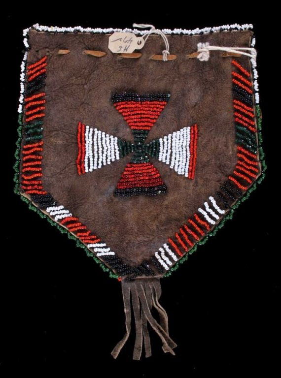 Cheyenne Beaded Pouch from Otto Ernst Collection: The pouch featrues 1800's trade glass seed bead work from the Cheyenne Native American Indians. The bag has a fancy beaded edge framing the piece with a center cross design. The bottom has cut fringe.