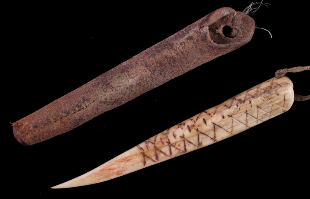 Crow Awl Case & Awl circa 19th Century: This is a hand carved and scrimshaw bone awl with saddle leather awl case from the Crow Native American Indians. The awl has a unique hand carved scrimshaw etched design across the front and fine shar