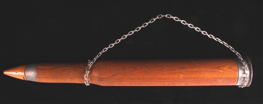 Large Wooden Bullet Display Sign: This is a large wooden bullet display sign. The body and tip of the bullet are made from wood. The bottom and part of the tip are made from steel. A chain is attached to hang the bullet. The sign show