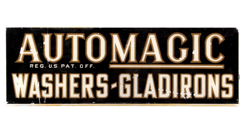 Automagic Washers-Gladirons Glass Sign: This is an original early glass back painted automotive advertising original sign that reads, "Automagic REG. U.S. PAT. OFF. Washers-Gladirons". The sign has a black background with gold outlined whit