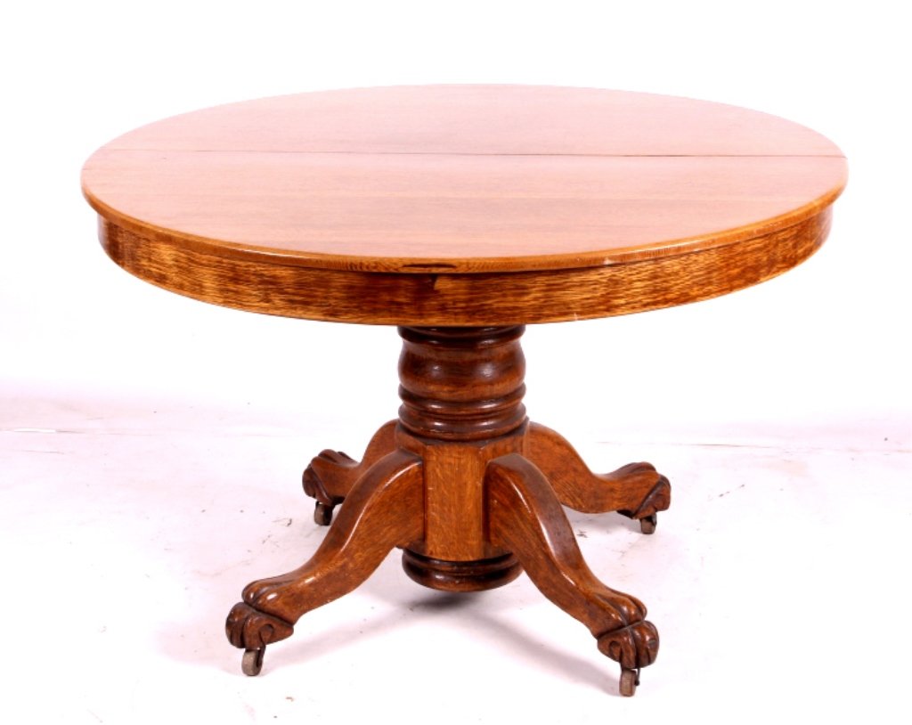 Antique Round Oak Table: This is an antique round oak table. The table features a beautiful pedestal with carved claw feet. The table is made from solid oak and is in good condition. The table measures 44.5" in diameter.