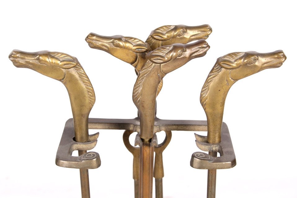 Horse Head Equestrian Western Brass Fireplace Set: The lot features a fireplace tool set in brass with unique and desirable horse head equestrian Western style. The set includes: art deco stand, shovel, broom, poker, and tongs. The antique set shows o