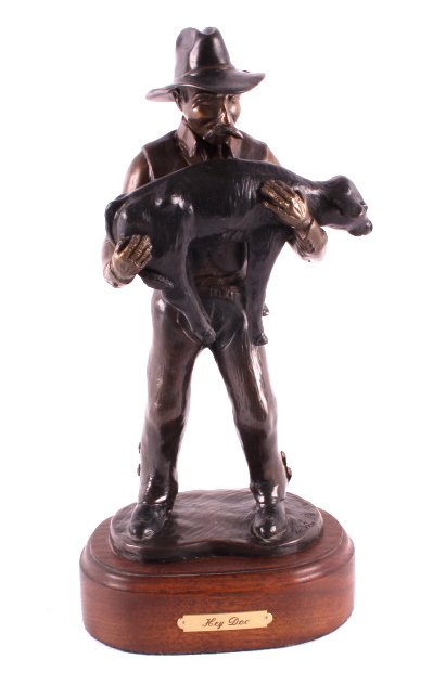 Cowboy with Calf Bronze Statue: This is an original bronze statue of a cowboy and a calf. The piece is titled "Hey Doc" and shows a cowboy holding a newborn calf. The statue shows incredible detail. The bronze has been signed by the
