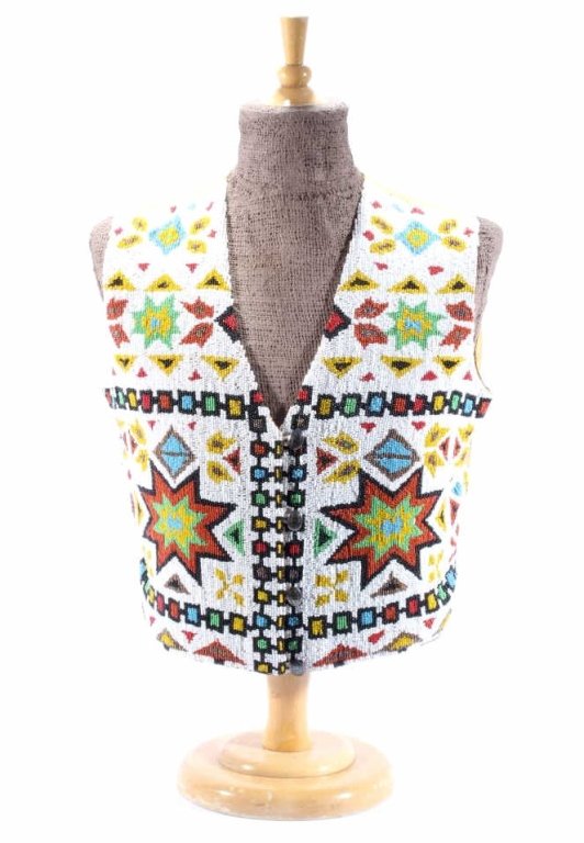 Sioux Fully Beaded Vest circa 1920-30: The vest shows a fully beaded front with excellent traditional geometric motifs and silver worked concho buttons. The piece is from the Sioux Native American Indians circa 1920-1930. The piece shows a