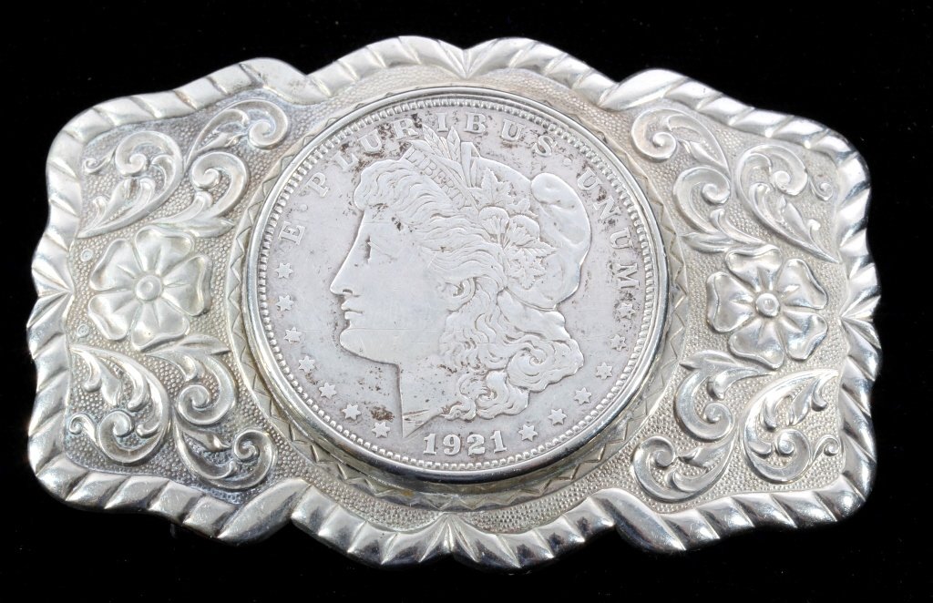 Navajo 1921 Morgan Silver Dollar Belt Buckle: This is a nickel silver floral belt buckle with a 1921 Morgan Silver Dollar in the center. The coin and buckle are in good condition. Measures 2 1/8"x3.25".