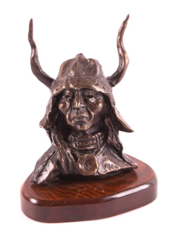 Blackfeet Artist Gordon Monroe Original Bronze: This is an original bronze sculpture by Blackfeet artist Gordon Monroe. The piece is titled "Med. Man" and shows a Medicine Man dressed in a horn and hide hat with a beaded necklace. The sculpture is