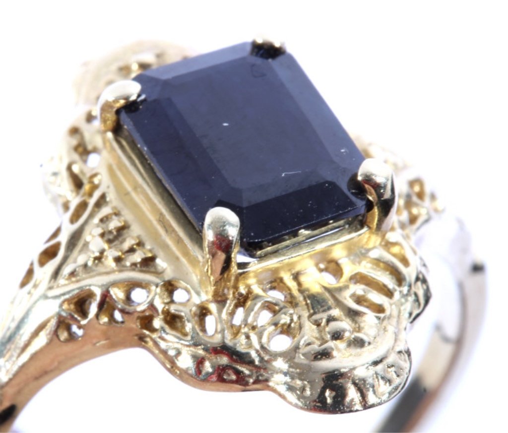 10K Gold & Dark Blue Sapphire Ring: The ring features an excellent natural untreated Dark Blue Sapphire in an emerald cut on a 10K Yellow Gold setting. The piece has an excellent Art Deco style and is in good condition. Ring is a size 9