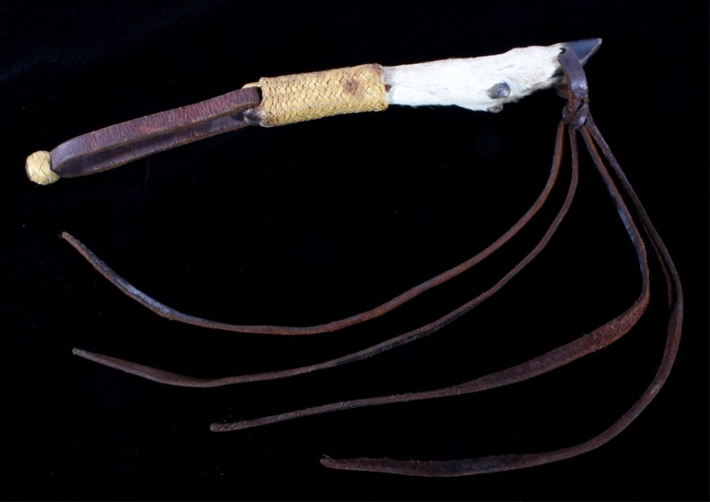 Early Vintage Montana Plains Deer Foot Quirt: This is a deer foot handled riding quirt from the Plains Native American Indians in Montana. The early vintage piece shows a braided leather or rawhide handle with deer foot hoof and saddle leather en