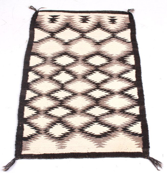 Navajo Eye Dazzler Saddle Blanket: This is a Navajo Natie American Indian hand knotted and mineral dyed saddle blanket with an excellent Eye Dazzler pattern. The rug shows well preserved condition and is in dark brown, grey, and white.