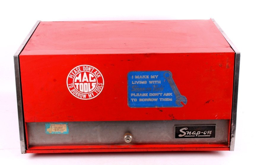 Snap-On Tool Box: This is a vintage Snap-On tool box. The tool box features a cover that lifts to show three storage drawers with a tool tray on top. The box is marked "Snap-On". The Snap-On tool box is in good overall