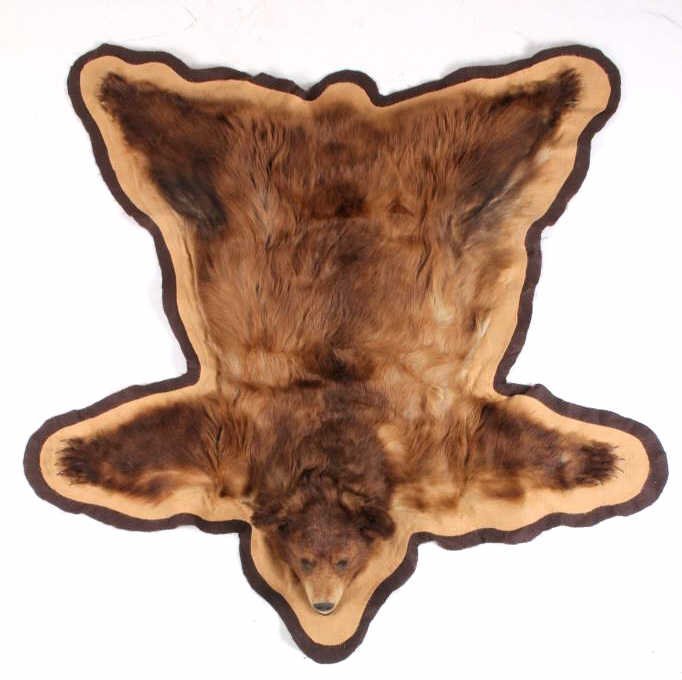 Montana Cinnamon Blonde Black Bear Rug: This is a Montana taken Black Bear rug with a Cinnamon Blonde coloring. The piece shows all of the impressive claws and a full mounted head with open mouth. The rug appears to be in good condition and