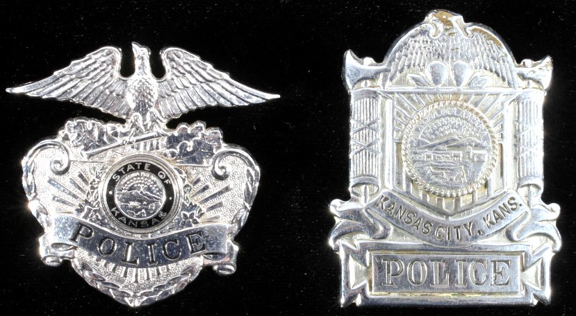 Kansas City Police Hat Badge Collection of Two: This lot features a collection of two State of Kansas Kansas City Police Hat badges. These both show a metal embossed construction and threaded connection for display on cap. The first has the black e