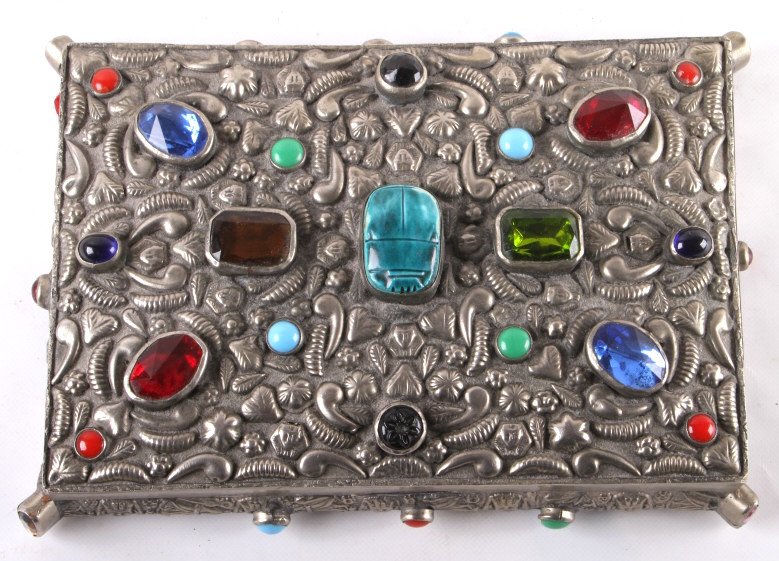 Antique Trinket box with Inlaid Gemstones: This lot features an antique trinket box with inlaid gemstones and turquoise. The inside of the box is lined with plush red cloth to keep items secure. The sides of the box feature even more elegant g