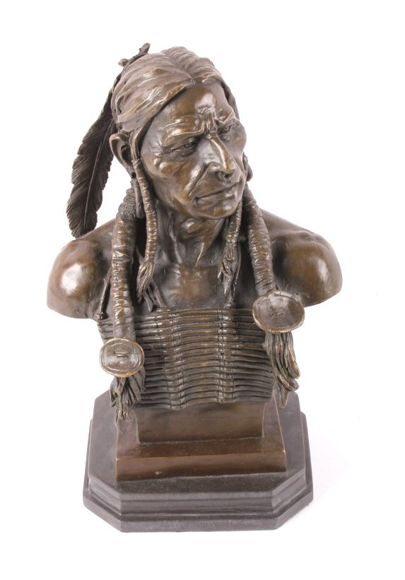Cast Bronze Native American Head Statue: This lot features a cast bronze Native American head statue. The piece displays a Native American man in tradition clothes. The piece is sign " Milo" which is artist Miguel Fernando Lopez. The piece i