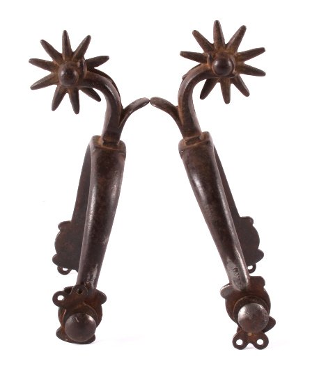 Antique Buermann Drop Shank Iron Spurs: This is a pair of antique Buermann drop shank iron spurs. Each spurs is marked with a star near one of the buttons. Near the other button is marked "Pat'd". The spurs have a substantially dropped shan