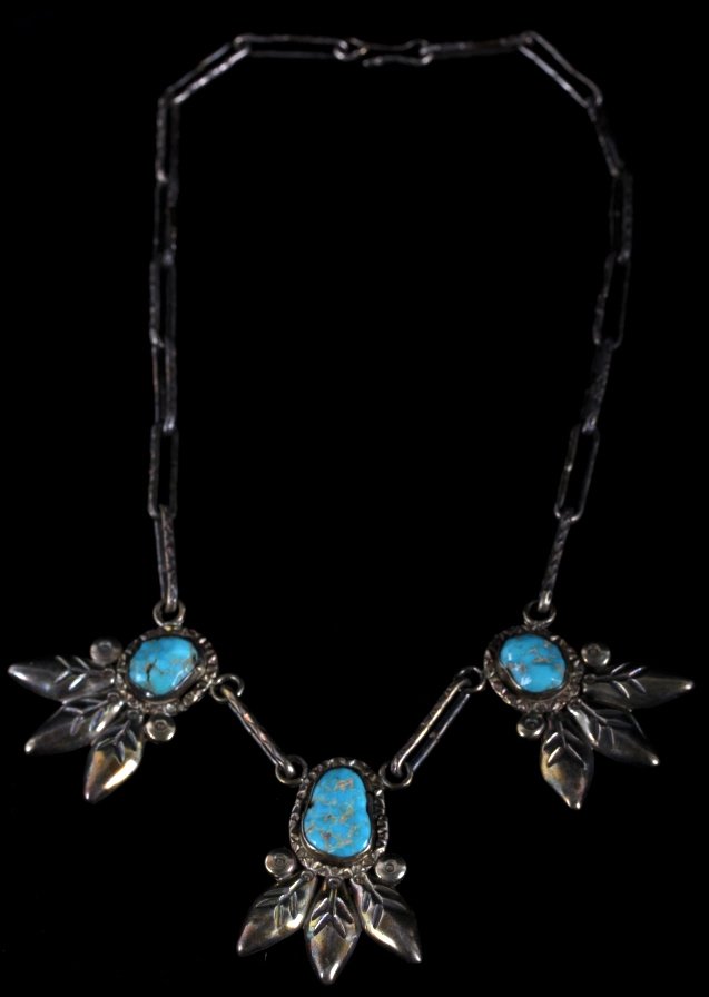 Signed Navajo Turquoise And Silver Necklace: This lot feature a Navajo signed turquoise and silver necklace. This necklace is in good condition for its age. It has three bright turquoise stone set in three silver feather pattern pendants. The tu