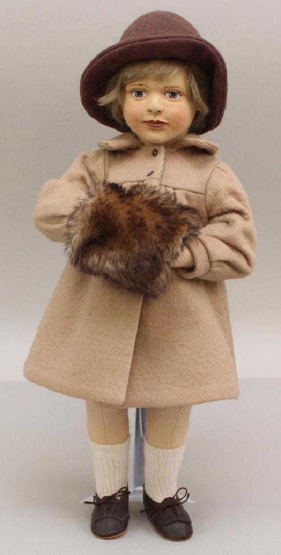 15" MIB TAGGED 1991 "ELIZABETH" BY ARTIST MAGGIE: All original Elizabeth doll dressed in camel felt coat, brown felt hat and tipped mohair muff. Leather shoes. Stand. Condition: box has writing on lid.