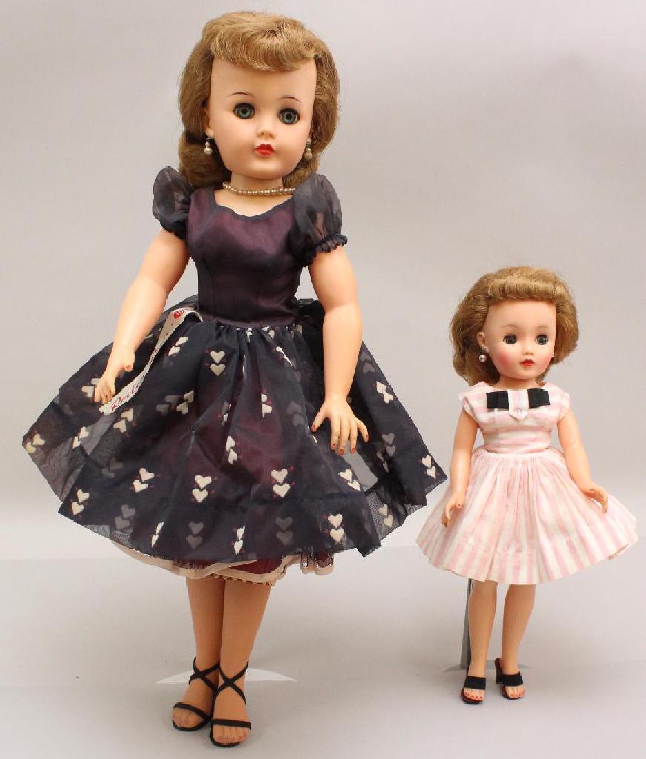 PAIR OF ALL ORIGINAL 1955-1959 VINYL IDEAL "REVLON": Both dolls have blue sleep eyes, honey blonde hair. 14" Doll is dressed in pink/white stripe cotton dress, nylon petticoat and panties. Pearl earrings. Black high heel sandals. Stand. Condition: age l