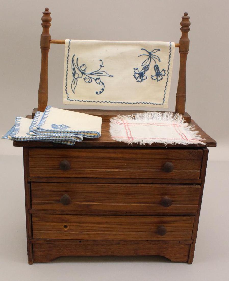 ANTIQUE DOLL SIZE OAK CHEST OF DRAWERS WITH LINENS. (1 of 2)