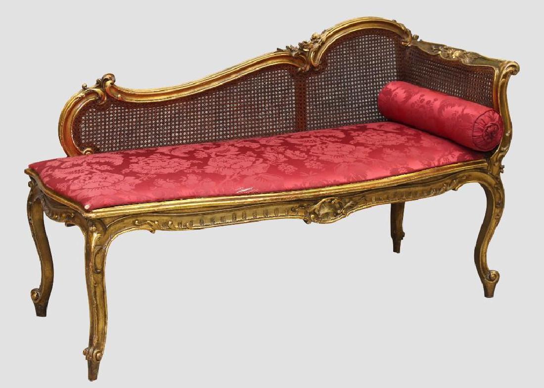 Louis XV Giltwood Diminutive Chaise Lounge: Carved C-scroll and floral crest on cabriole legs with a cane back and damask fabric bed, 27"h x 48"w x 19"d