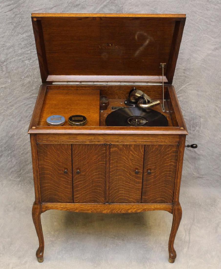 Victor Talking Machine Victrola: Model VV-210, Serial No. 197248, Oak casing with complimenting playing discs, 32"h x 28"w x 20.5"d. 