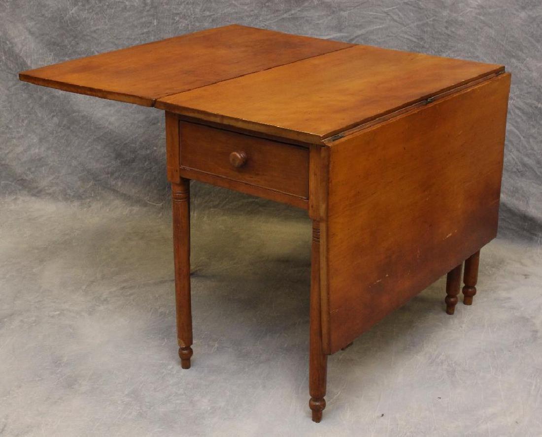 Cherry Drop Leaf Table: Single drawer on turned legs, 29"h x 58"w (open), 18.5"w (closed) x 36"d.