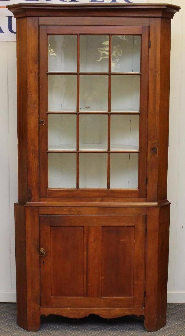 Pennsylvania Cherrywood Corner Cupboard: Two sectional with one twelve glazed panel door over one door with a shaped apron and feet, 89"h x 44" w x 20"d. Piece of corner molding is missing.