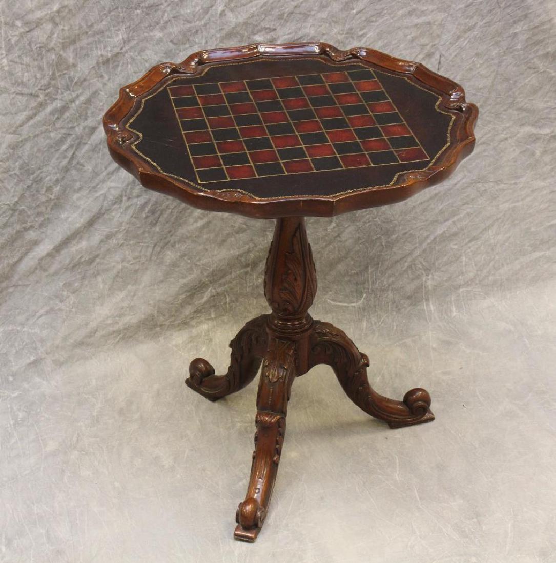 Carved Mahogany Games Table: Pie crust leather inset checkerboard top with a carved acanthus pedestal and cabriole legs, 23"h x 20"rd.