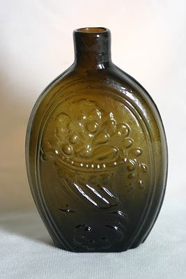 Eagle and Cornucopia Flask.: Pint size flask in yellow olive green with American Eagle on front and cornucopia on reverse. Open pontil. 6 3/4" tall. No noted damage.