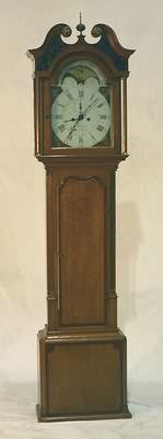 George III Oak Tall Case Clock.: Broken scroll pediment with centering brass finial, arched glazed door opening to white painted dial with small second hand dial and multicolored moon dial, works by William Bellman/ Broughton, circa