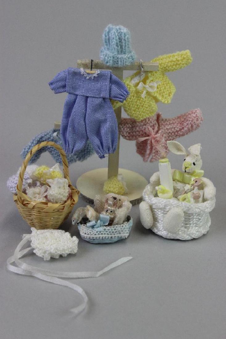 Display stand for window, clothes, knitted items, box: Display stand for window blue baby boy clothes Falcon, knitted items Luned Davis; Baby booties in basket Luned Davis; Baby box Silvia Leiner