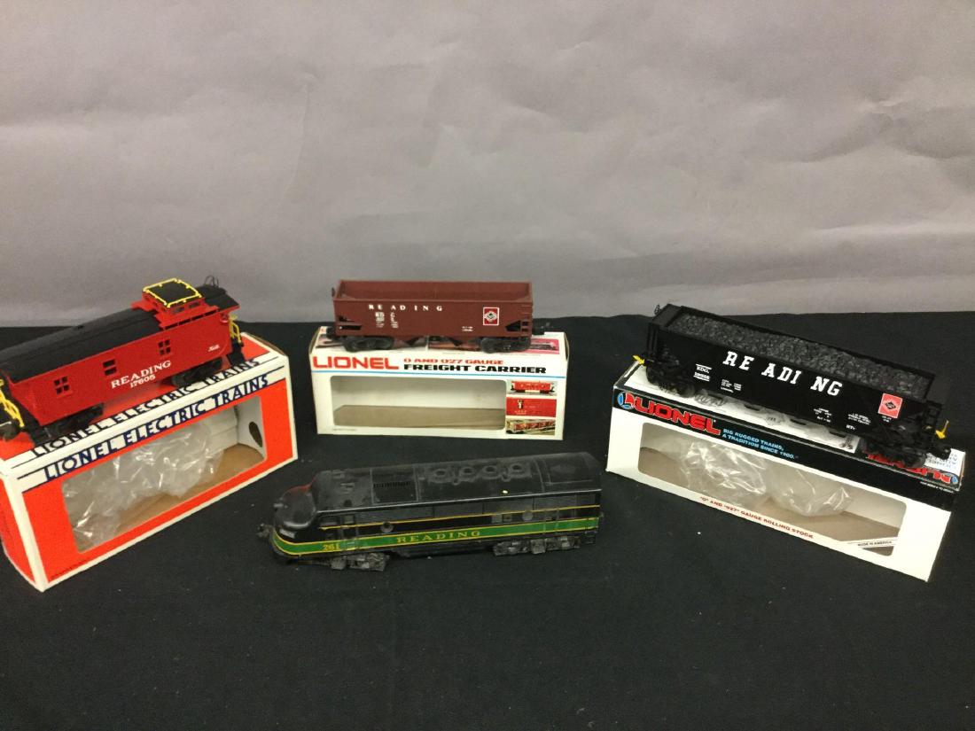Grouping of four Lionel Trains: Reading 261 engine, Reading Hopper with coal load 6-19312, Reading standard O caboose 6-17606, Reading operating Harper 6-6105.