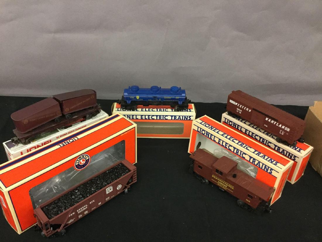 Grouping of five Lionel Trains: Pennsylvania flag car with trailers 6-16303, LCCA convention Pittsburgh PA four Bay hopper car 6-52266, Pennsylvania salt three dome tankcar 6-16124, Pennsylvania extended vision caboose with smoke 6-