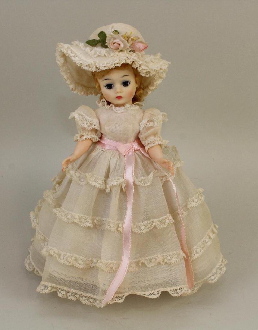 1969 MADAME ALEXANDER CISSETTE TAGGED "SOUTHERN BELLE",: Blonde hair. Dressed in white organdy gown with four rows of lace, pink sash. Matching hat with floral trim. Original pink high heel sandals. Stand. Condition: clothing has some age discoloration