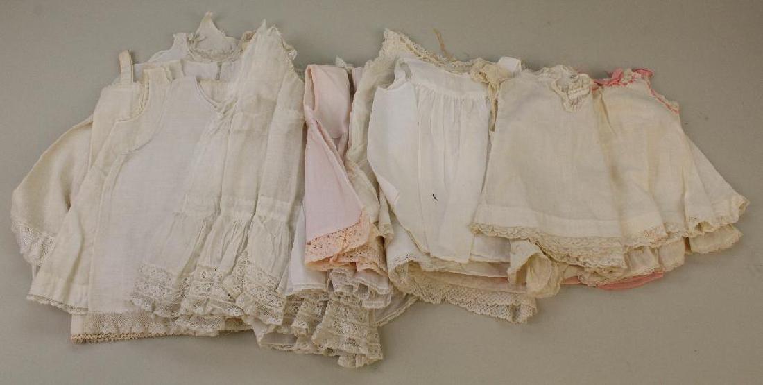 BODY PARTS & SUPPLIES: LOT OF ANTIQUE DOLL PETTICOATS.: (21) Cotton full petticoats. 9" - 13" (3) are pink, the remainder white. Condition: minor age discoloration on some.