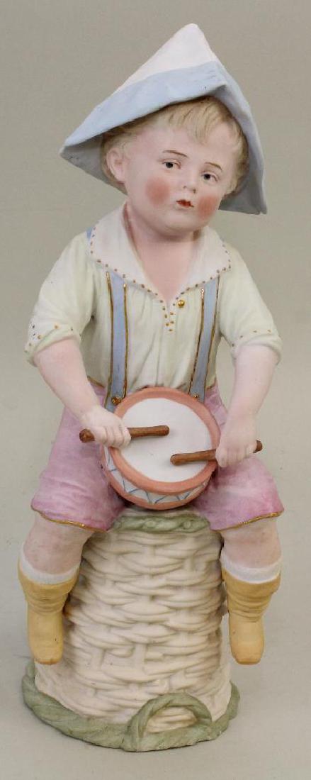 13" MARKED HEUBACH FIGURINE: BOY PLAYING DRUM. (1 of 2)