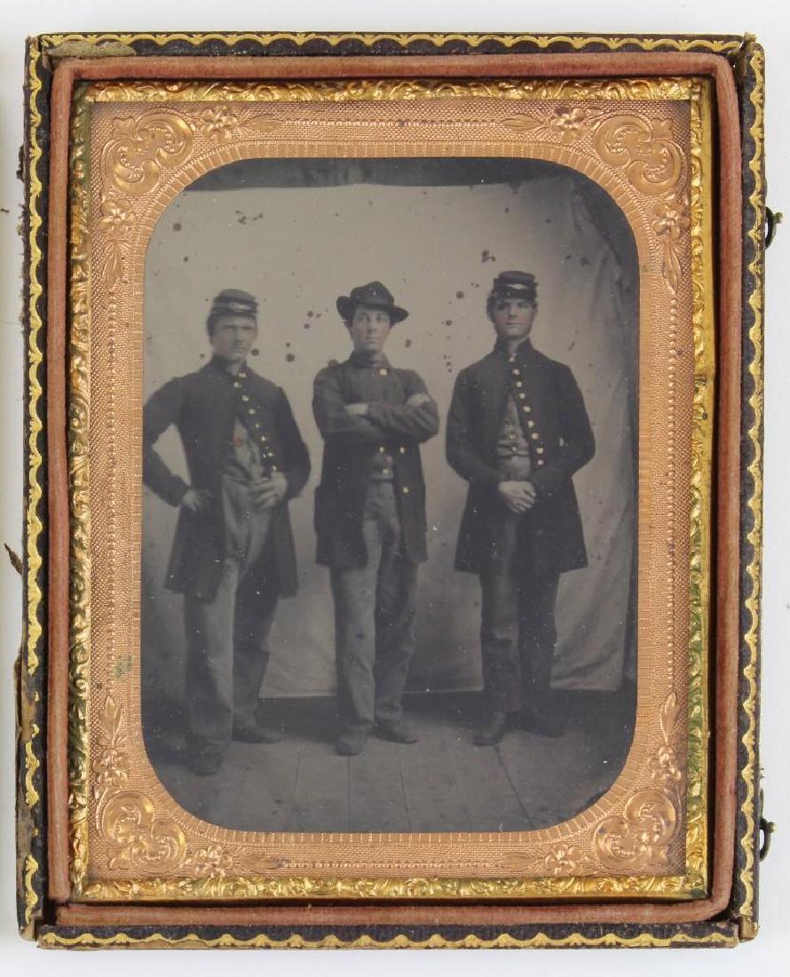 Tintype of Civil War Soldiers: Quarter-plate tintype of Union Civil War soldiers showing three full standing uniformed soldiers wearing kepis or slouch hats. Interior of case features ink inscription "Mr. John Wilson, Mr. D.G. Fuld