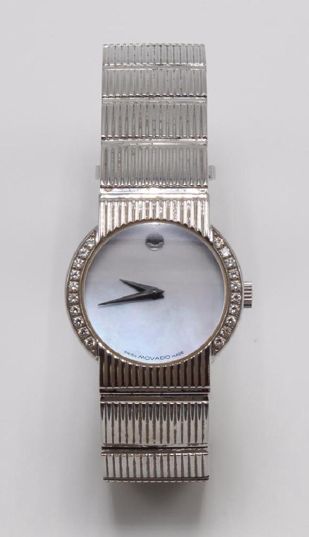Ladies Movado Wrist Watch with Diamonds. Stainless: 26mm diameter case. 8" long X 16mm wide band with invisible butterfly style deployment band. Mother of Pearl face. Bezel features (20) round Diamonds, approx. .30ctw. Quartz. Swiss Made. Water-Re
