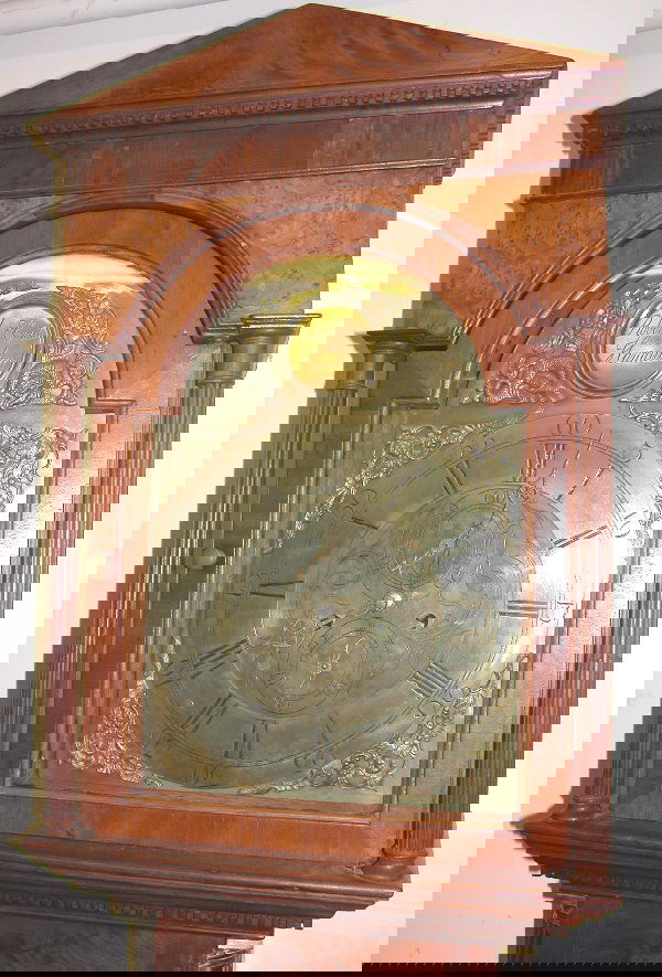 English Tall Case Clock.: Tall case clock having mahogany case with figured veneer, peaked top with dentil molding, reeded pilasters, trunk with reeded quarter columns and brass capitals, shaped door, brass dial, 8-day works w