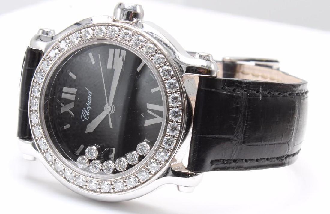 Ladies Chopard Happy Sport Diamond and 18K White Gold: Black face with Roman Numerals at the quarter hours and markers between. Date window. Features (7) bezel set floating Diamonds and a watch bezel set with (34) round brilliant cut Diamonds, each approx