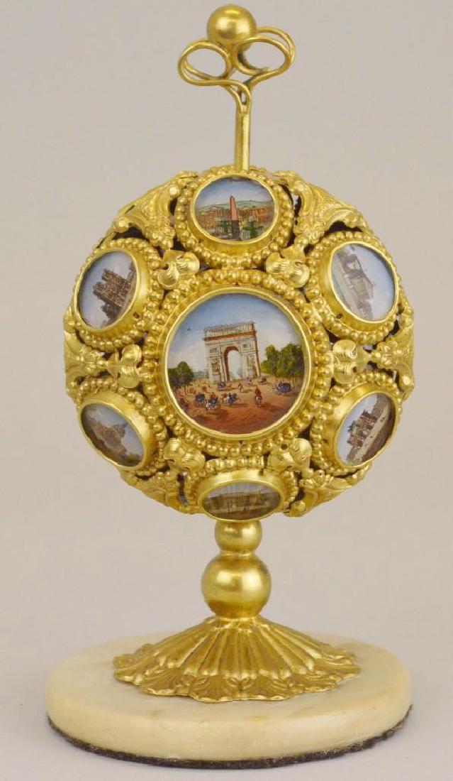 French Napoleon III Palais Royal Mechanical Scent Caddy: Ormolu decorated construction with medallions featuring painted scenes of Paris. Does not include interior bottles. 7"h x 3.5"round