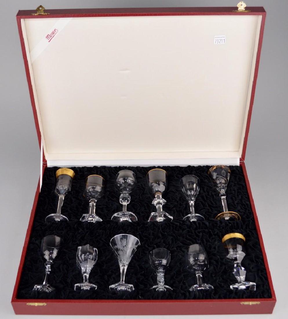 Moser 6/I Liquor Set in Presentation Case: Includes 12 mouth-blown and cut, engraved or gilded in 24 carat gold by hand miniature liquor glasses. Includes original velvet-lined presentation case. The 12 styles included are: Maharani, Pope,Sple