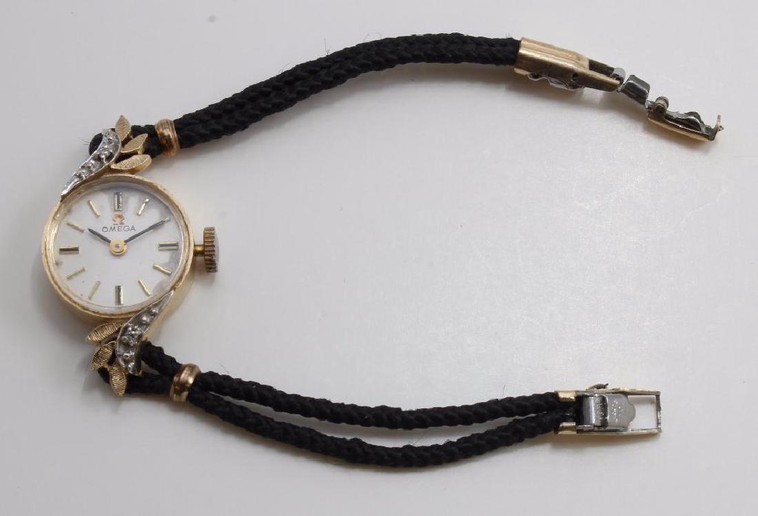LADIES OMEGA WRIST WATCH. DIAMOND. 14K YELLOW AND WHITE: 6" LONG. 32.4MM LUG END TO LUG END. FEATURES (2) ROUND ACCENT DIAMONDS. SHOWS SOME WEAR ON DIAL. 17 JEWELS. 485. SERIAL #34591695 BLACK CORD BRACELET. 6.4GTW WITH BRACELET, WITHOUT MOVEMEN
